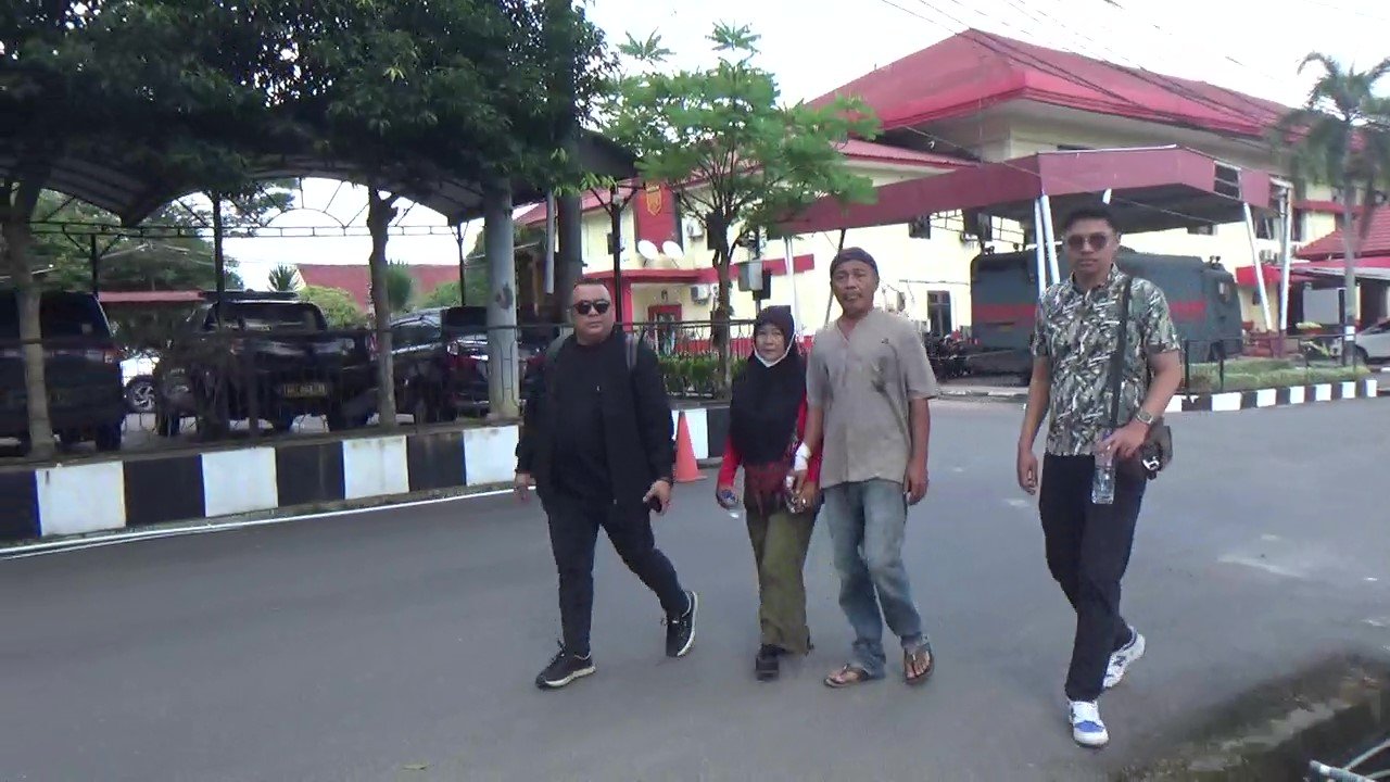 Didampingi kuasa hukum Dr. M. Sa'i Rangkuti, S.H., M.H (pakai Kaca Mata Hitam) dan Suaminya, Ibu M. Azizan menuju di Kantor Bidpropam Polda Sumatera Utara, Medan untuk membuat laporan dugaan salah tangkap dan penembakan,Sabtu pagi 14 Februari 2026. (kedannews.co.id /Foto: Aris Sinurat).